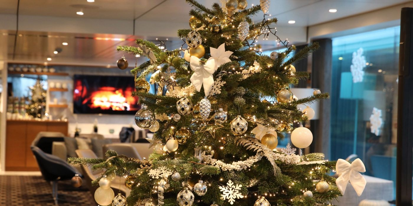 Festive Christmas tree adorned with colorful ornaments and twinkling lights onboard our Scenic Space-Ships