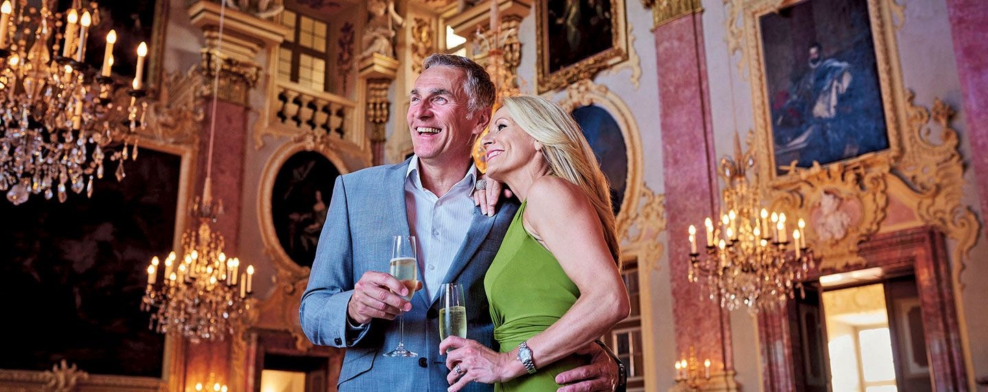 Guests holding champagne in the ornate Palace of Rastatt ballroom